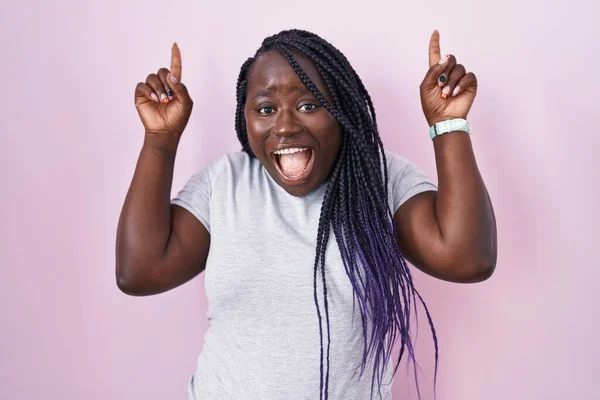 Jonge Afrikaanse Vrouw Staat Roze Achtergrond Glimlachend Verbaasd Verrast Wijzen — Stockfoto