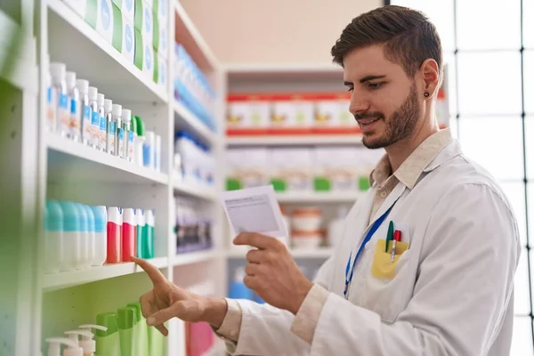 Young Caucasian Man Pharmacist Reading Prescription Holding Product Shelving Pharmacy —  Fotos de Stock