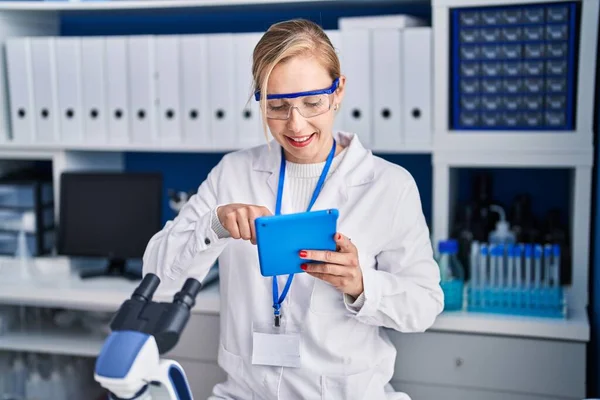Mujer Joven Rubia Científica Sonriendo Confiada Usando Touchpad Laboratorio —  Fotos de Stock