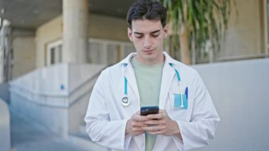 Genç İspanyol doktor hastanede akıllı telefon kullanıyor.