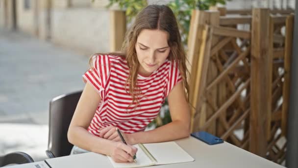 Mujer Rubia Joven Sentada Mesa Escribiendo Cuaderno Terraza Cafetería — Vídeos de Stock
