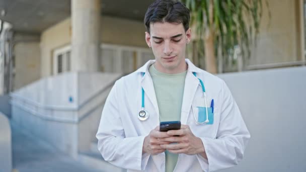 Joven Médico Hispano Usando Smartphone Hospital — Vídeo de stock