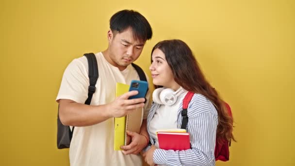 Чоловік Жінка Студенти Тримають Книги Допомогою Смартфона Над Ізольованим Жовтим — стокове відео