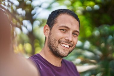 Young man smiling confident making selfie by the camera at park