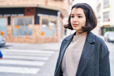 Young woman looking to the side with relaxed expression at street