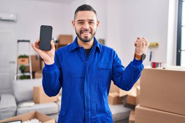 İspanyol adam hareket servisi üzerinde çalışıyor. Akıllı telefon ekranında gururla bağırıyor, zaferi ve başarıyı kutluyor. 