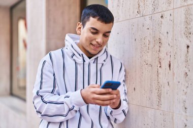 Sokakta akıllı telefon kullanan kendine güvenen genç adam.