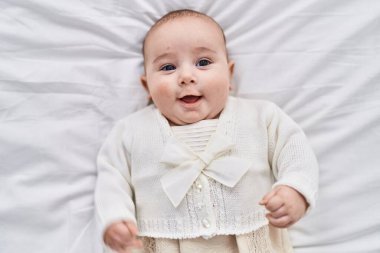 Sevimli bebek yatakta kendinden emin bir şekilde yatıyor.