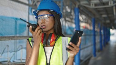Afro-Amerikan kadın mimar sokakta telsizle konuşan akıllı telefon ekranı.