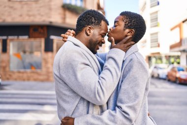 Man and woman couple hugging each other standing at street