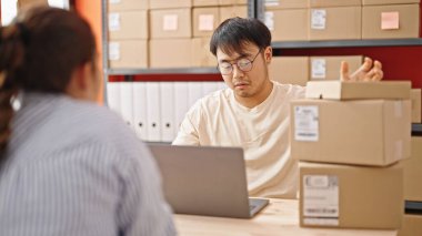 Erkek ve kadın dış ticaret işçileri ofiste dizüstü bilgisayar kullanıyorlar.