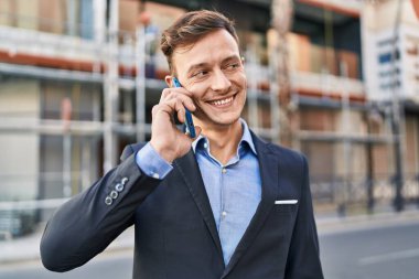 Young man business worker smiling confident talking on smartphone at street