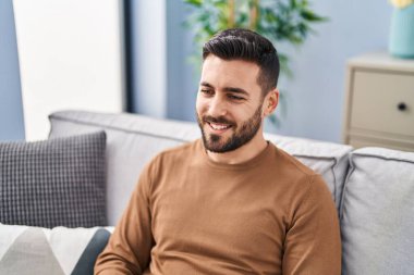 Kanepede oturan İspanyol genç adam konuşuyor.