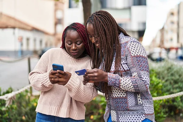 ストリートでスマートフォンやクレジットカードを使っているアフリカ系アメリカ人女性の友達 — ストック写真