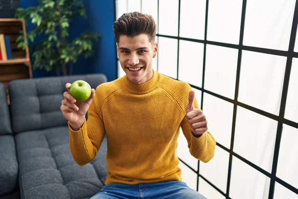 Jovem Hispânico Homem Segurando Maçã Verde Sorrindo Feliz Positivo Polegar — Fotografia de Stock