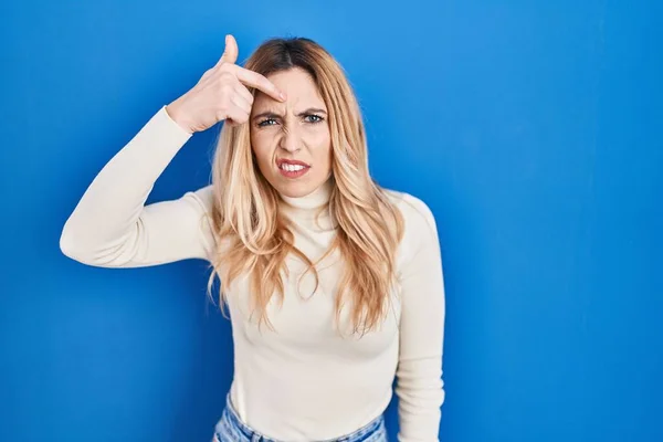 Young Caucasian Woman Standing Blue Background Pointing Unhappy Pimple Forehead — ストック写真