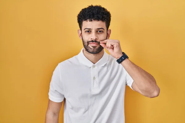 Arap Adam Sarı Arka Planın Başında Duruyor Ağzı Dudakları Parmaklarıyla — Stok fotoğraf