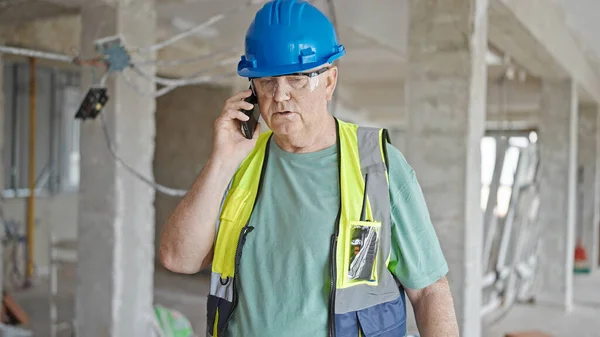 Medelålders Gråhårig Man Byggmästare Talar Smartphone Med Avslappnad Uttryck Byggarbetsplatsen — Stockfoto
