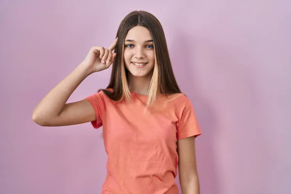 Tiener Meisje Staan Roze Achtergrond Glimlachen Wijzend Naar Hoofd Met — Stockfoto