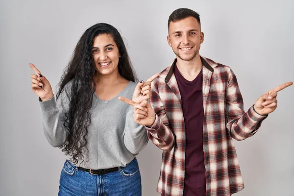Young Hispanic Couple Standing White Background Smiling Confident Pointing Fingers — Stock Photo, Image