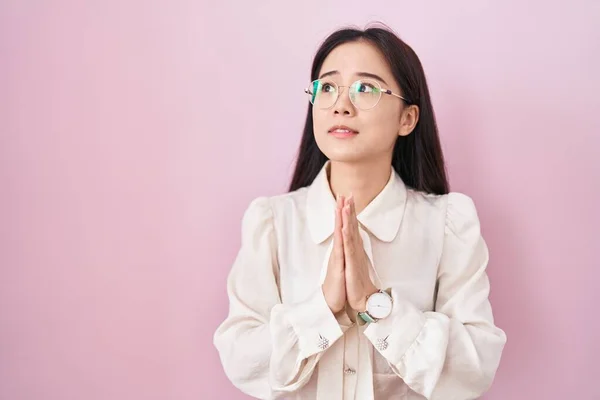 Молодая Китаянка Стоящая Розовом Фоне Умоляя Молясь Руками Вместе Выражением — стоковое фото