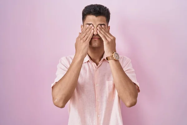 年轻的惊慌失措的男人站在粉色背景的旁边揉揉眼睛以消除疲劳和头痛 困倦和疲倦的表情 视力问题 — 图库照片