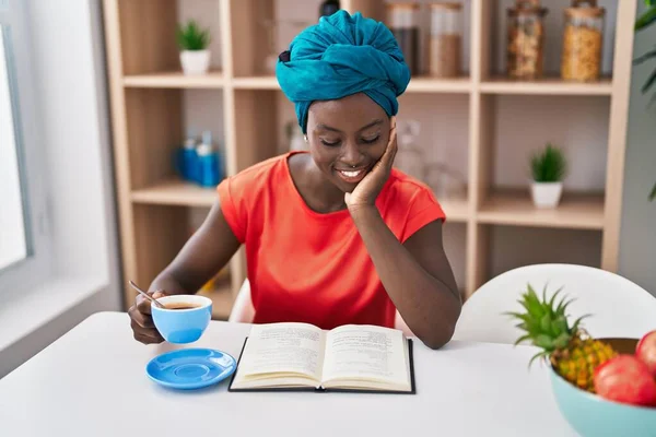 Mladá Africká Americká Žena Pije Kávu Čtení Knihy Doma — Stock fotografie