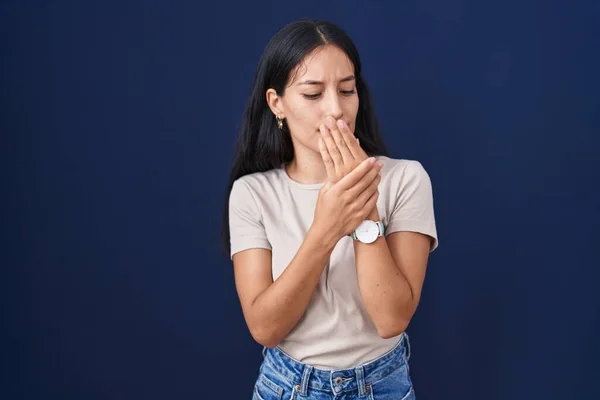 青い背景の上に立つ若いヒスパニック系の女性手や指の痛み 関節炎の炎症 — ストック写真