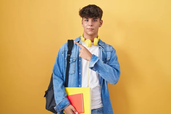 Adolescente Hispânico Usando Mochila Estudantil Segurando Livros Apontando Com Dedo — Fotografia de Stock