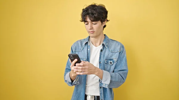Young Hispanic Man Using Smartphone Serious Expression Isolated Yellow Background — Stock Photo, Image