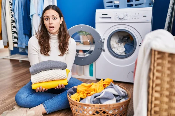 Young Hispanic Woman Holding Clean Laundry Shock Face Looking Skeptical — Stock Photo, Image