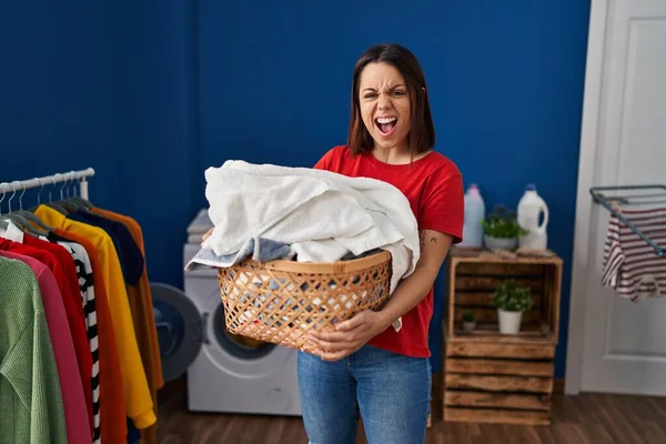 Young Hispanic Woman Holding Laundry Basket Angry Mad Screaming Frustrated — 图库照片