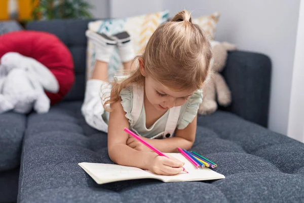 Liebenswerte Blonde Mädchen Vorschulkind Sitzt Auf Sofa Zeichnung Auf Notizbuch — Stockfoto