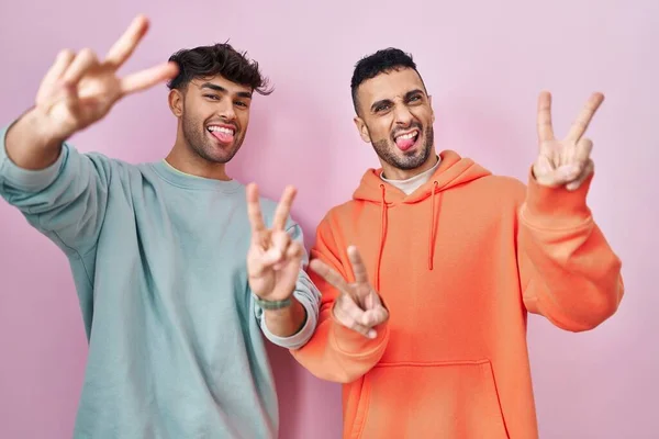 Jong Hispanic Gay Paar Staande Roze Achtergrond Glimlachen Met Tong — Stockfoto