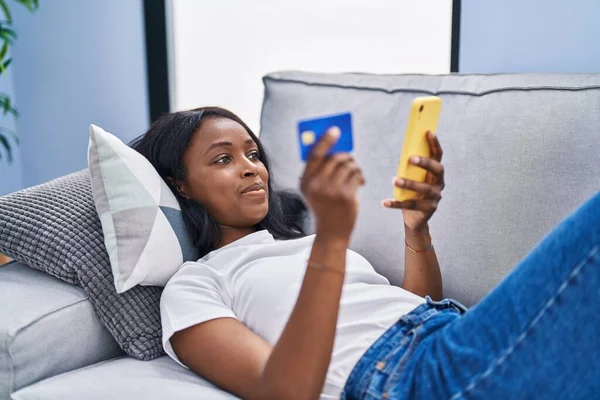 Mujer Afroamericana Joven Usando Teléfono Inteligente Tarjeta Crédito Sentado Sofá —  Fotos de Stock