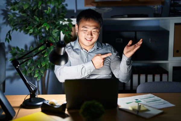 Молодой Китаец Работающий Ноутбуком Ночью Поражен Улыбается Камеру Показывая Рукой — стоковое фото