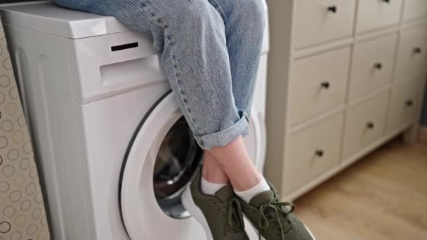 Junge Blonde Frau Trinkt Kaffee Sitzend Auf Waschmaschine Waschküche — Stockvideo