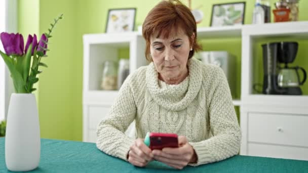 Mature Hispanic Woman Holding Vape Inhaler Sitting Table Using Smartphone — Stock Video
