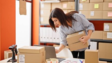 Genç Kafkas kadın ekomünikasyon işçisi ofiste dizüstü bilgisayar paketi kullanıyor.