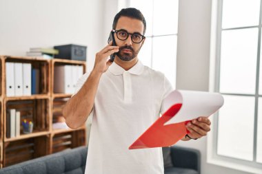 Genç İspanyol psikolog, psikoloji merkezindeki akıllı telefon okuma raporuyla konuşuyor.