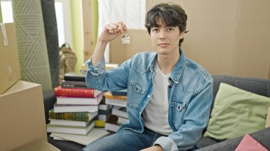 Genç İspanyol adam elinde yeni evin anahtarlarını tutuyor.