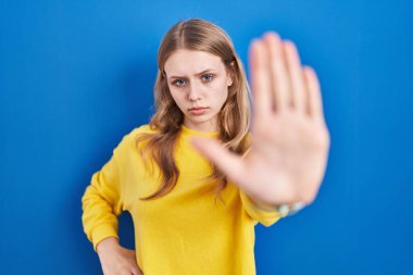 Mavi arka planda dikilen beyaz bir kadın avucunun içinde şarkı söylemeyi kesiyor. Yüzünde olumsuz ve ciddi bir jest olan uyarı ifadesi. 