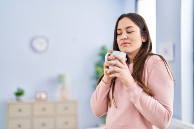 Evde kahve kokusu alan genç bir kadın.