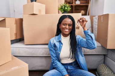 African american woman smiling confident holding key at new home