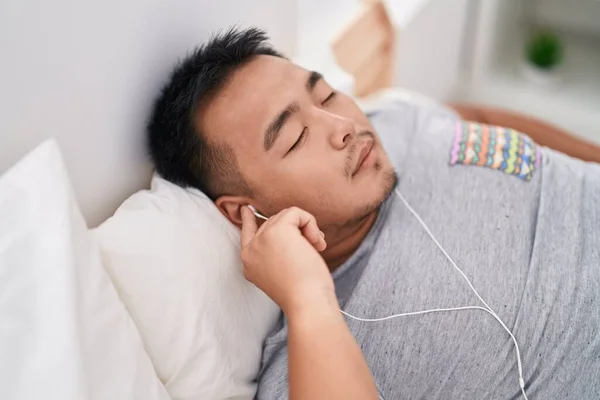 Junger Chinese Hört Musik Schlafend Auf Bett Schlafzimmer — Stockfoto