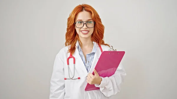 年轻的红头发女医生拿着剪贴板 对着孤立的白色背景微笑 — 图库照片