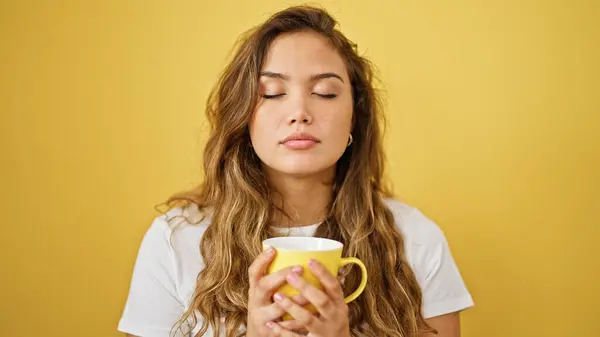 Jovem Bela Mulher Hispânica Cheirando Xícara Café Sobre Fundo Amarelo — Fotografia de Stock