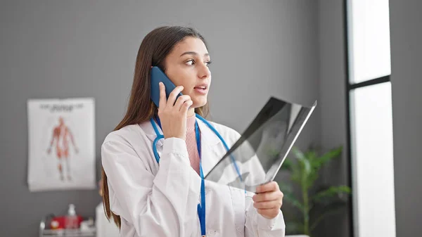 Νεαρή Όμορφη Ισπανίδα Γιατρός Ψάχνει Ακτινογραφία Μιλώντας Smartphone Στην Κλινική — Φωτογραφία Αρχείου