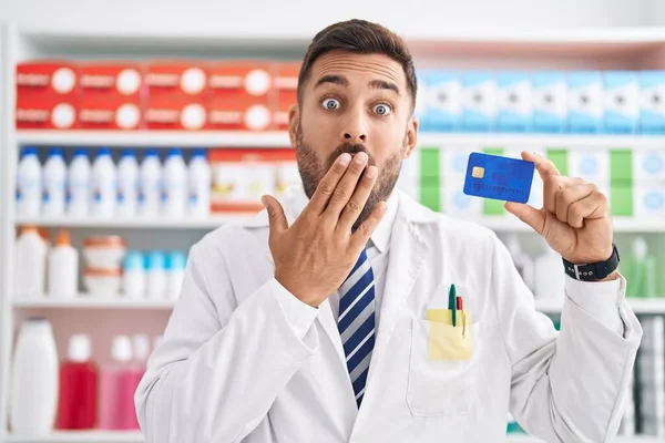 Handsome Hispanic Man Working Pharmacy Drugstore Holding Credit Card Covering — Stock Photo, Image