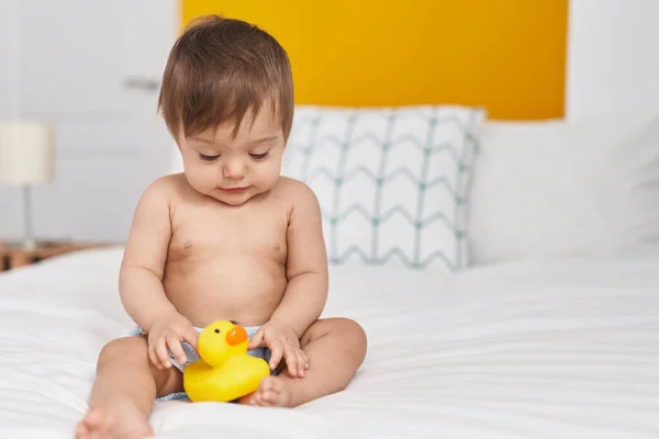Liebenswertes Kaukasisches Baby Sitzt Auf Bett Und Spielt Mit Entenspielzeug — Stockfoto